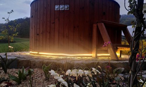 Holz Badefass im Garten mit Beleuchtung und Blumenbeet