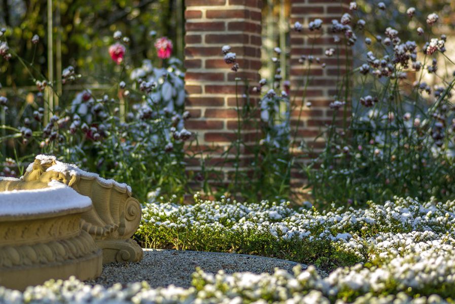 Harmonisch gestalteter Ziergarten mit Staudenbeet und Natursteinelement